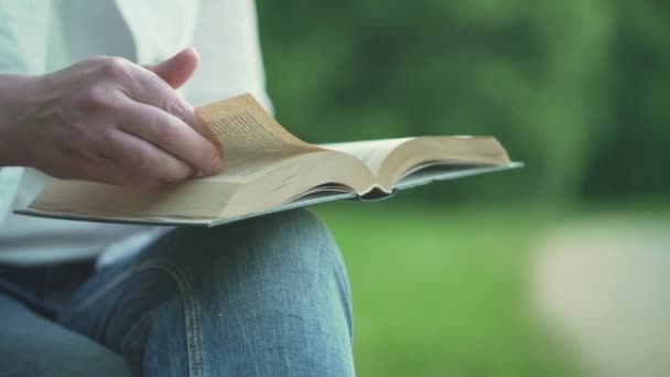 Dáma v bílém denimovém kabátě čte knihy. — Stock video