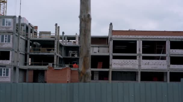 Bagian depan bangunan yang belum selesai dengan jendela non-glazed di pagar — Stok Video