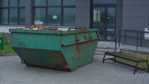 Recipiente de metal enferrujado verde com detritos de tijolo na construção — Vídeo de Stock