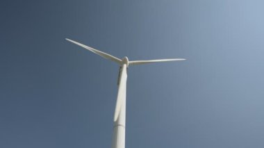 Beyaz yel değirmeni, açık mavi gökyüzüne karşı oluşturulan güneş enerjisi.