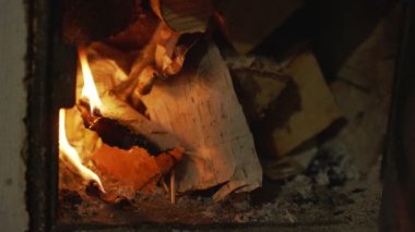Sarı ve turuncu alevler sobadaki kağıt tabakalarında yanar.