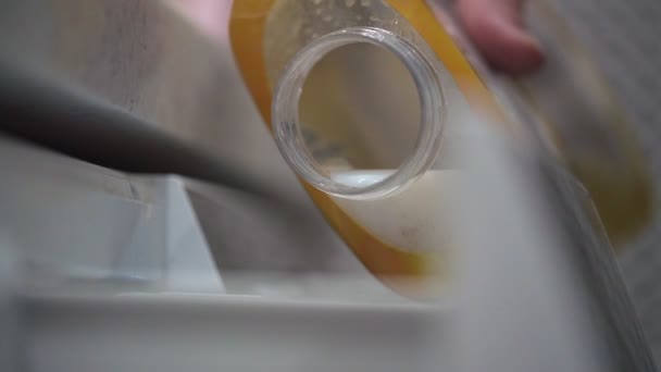 Hausfrau schüttet verschwindende Klimaanlage in Waschmaschine — Stockvideo