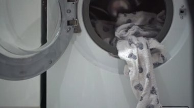Terry pijamaları banyodaki çamaşır makinesinden sarkıyor.