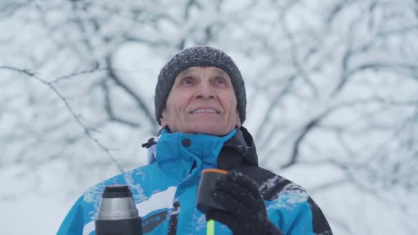 Uomo deliziato in giacca invernale sportiva beve bevanda calda — Video Stock