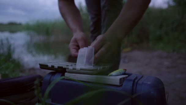 Visser probeert te krijgen tackle met zijn vingers uit visdoos — Stockvideo