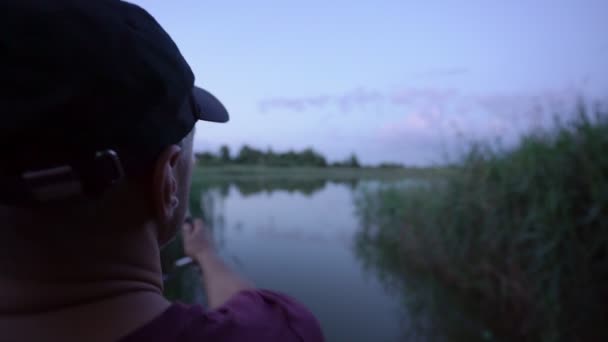 Pêcheur jette tournant dans le lac de rivage gros plan — Video