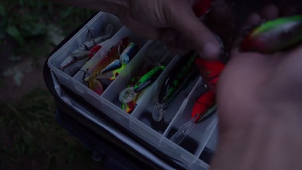 Pescatore svela wobblers e mette dalla scatola di pesca all'aperto — Video Stock