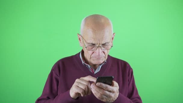 Старший мужчина с плохим зрением носит очки с помощью смартфона — стоковое видео