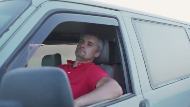 Pensativo cansado homem descansando em minivan colocando a mão na janela lateral aberta — Vídeo de Stock