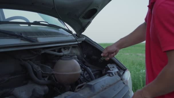 Homme près de minifourgonnette voiture avec capot surélevé enlève les contrôles de la sonde niveau d'huile moteur — Video