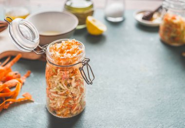 Kavanozlarda havuç salatası. Sağlıklı öğle yemeği için mutfak masasında arka planda. Fotokopi alanı olan ön manzara. Vejetaryen yemeği, düşük kalorili sebze yeme ve kilo kaybı diyeti.