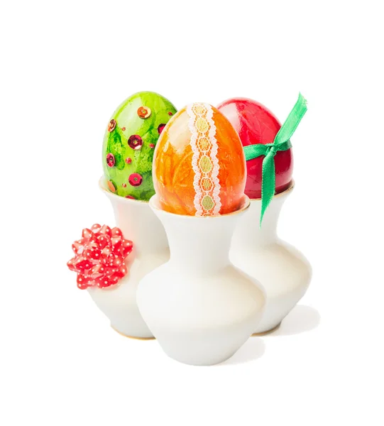 Tres huevos de Pascua de colores en taza con cinta sobre fondo blanco —  Fotos de Stock