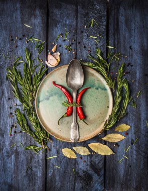 Aromatik otlar ve baharatlar platte, koyu mavi ahşap arka plan, kaşık ile görünümü top