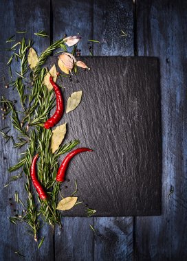 Spices food background with slate on blue wooden table, top view, place for text clipart