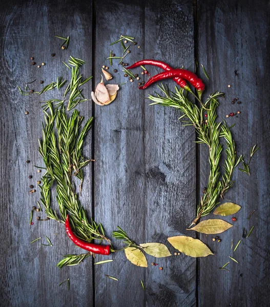 Herbs and spices round empty frame on blue wooden background, top view, place for text