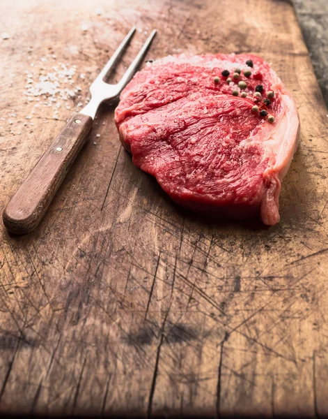 RAW ryggbiffen biff på gamla urtagning ombord med kött gaffel — Stockfoto