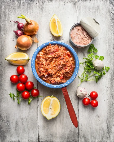Tomato sauce with canned tuna in rustic pot with vegetables and spices, white wooden background, top view — Stock Photo, Image