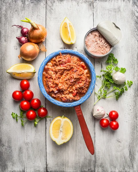 Molho de tomate com atum enlatado em panela rústica com legumes e especiarias, fundo de madeira branco, vista superior — Fotografia de Stock