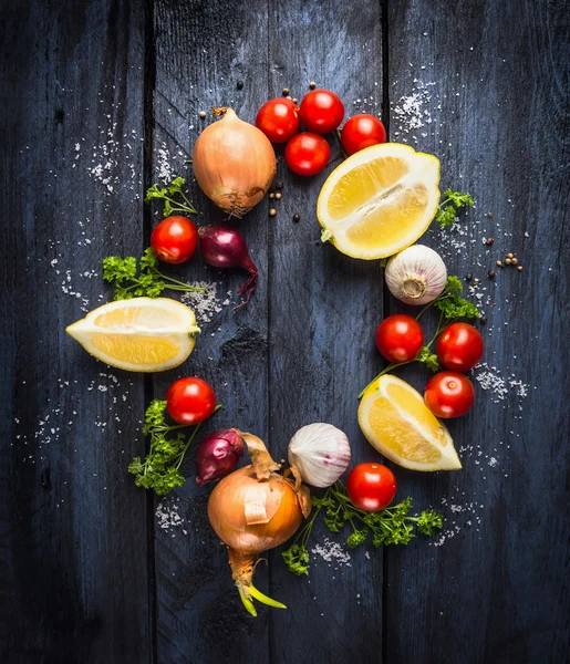 Tomatoes with herbs and spices, ingredient for tomato sauce on blue wooden background, frame, top view