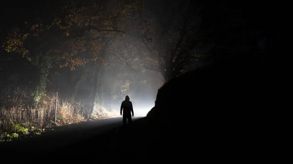 Hooded Figure Silhouetted Glowing Bright Light Country Road Foggy Winters — Stock Photo, Image