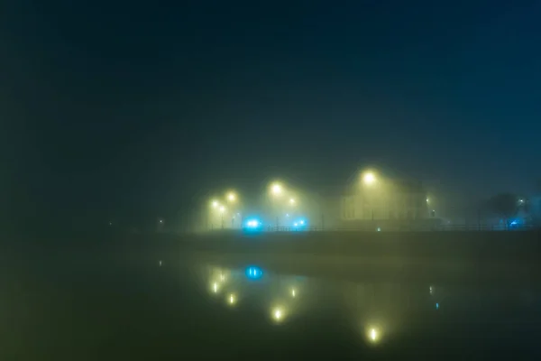 雾蒙蒙的冬夜 街道上的灯光和建筑物映照在一条河里 英国伍斯特 — 图库照片