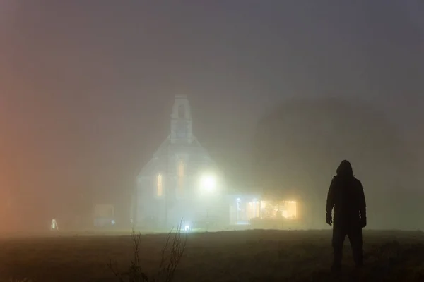 Strašidelná Postava Kápi Stojící Před Kostelem Rozzářila Atmosférické Mlze Zimní — Stock fotografie