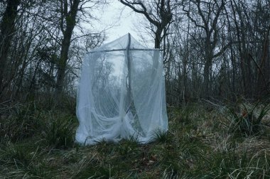 Korkunç, fantezi bir haç konsepti. Kış ortasında ürkütücü bir ormanın ortasında çarşafla kaplanmış..