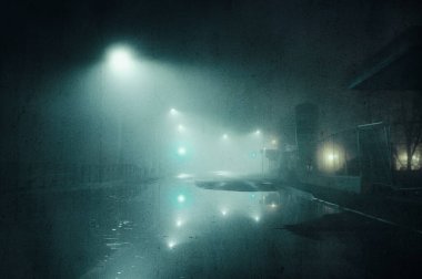 Şehirde sisli bir kış gecesinde sokak ışıklarıyla kaplanmış kasvetli bir yol konsepti. Bir grunge, sanatsal, düzenleme