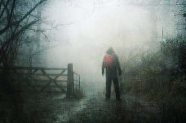 Karamsar, sisli bir kış gününde, ürkütücü bir ormanın içinden geçen sırtında sırt çantasıyla bir yolda yürüyüş yapan ürkütücü bir kavram. Bir grunge, soyut düzenleme ile.