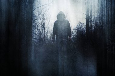 Yüzü olmayan kapüşonlu bir figürün, kışın ormanda durması. Bir grunge, sanatsal, düzenleme