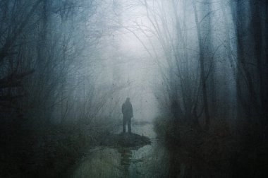 Kışın ormanda bir orman deresinin kenarında duran korkunç bir figür konsepti. Bir grunge, sanatsal, düzenleme