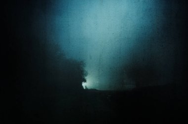 Sisli bir gecede sokak lambasıyla kırsalda bir yol kavramı. Bir grunge, sanatsal, düzenleme