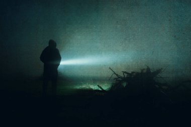 Kapüşonlu ve elinde meşaleyle kırsal kesimde kasvetli bir gecede karanlığa bakan ürkütücü bir figür. Bir grunge, soyut düzenleme ile.
