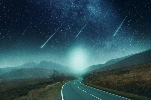 A mountain road going into the distance. With shooting stars heading towards the earth, against the night sky, With an abstract, artistic, edit