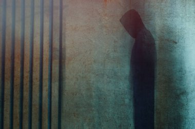 Ürkütücü terk edilmiş bir odada çürüyen duvarları olan kapüşonlu bir hayalet. Bir retro ile, ışık sızar düzenleme.          