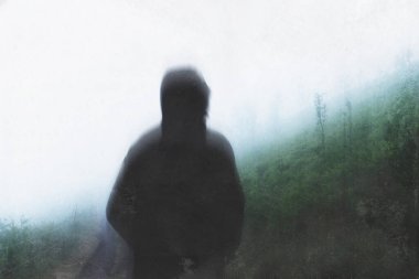 Kapüşonlu kapüşonlu, kasvetli bir atmosferik günde sisli bir yamaca bakan bir yola bakan kasvetli bir figür. Soyut, grunge, düzenle.