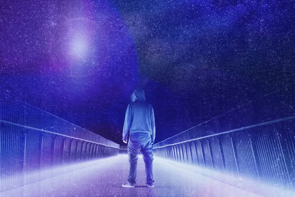 A mysterious hooded figure standing on a path. Silhouetted against bright lights at night. Looking at a UFO in the sky. Overlayered with a neon, retro, vapor wave edit.