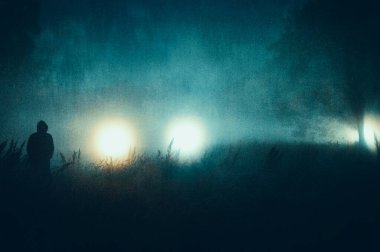 Huysuz bir korku konsepti, parlayan gizemli ışıklara karşı kapüşonlu bir siluet. Sisli ve ürkütücü bir gecede. Bir grunge, sanatsal düzenleme ile