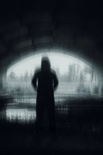 一个奇怪的头戴头巾的人影 在隧道入口处被人影勾勒出来 带有恐怖的 黑白模糊的 垂直编辑 — 图库照片