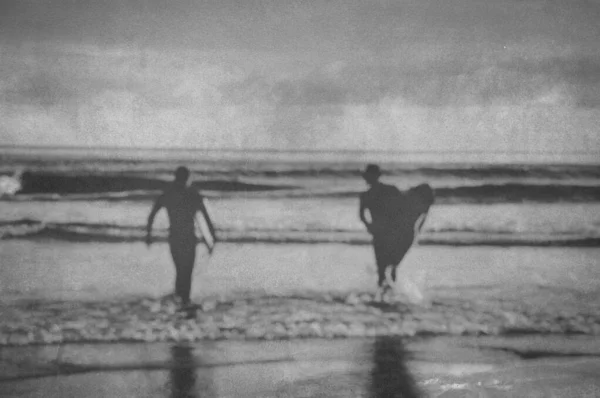 冲浪者带着冲浪板入海的轮廓 带着模糊编辑的老式过滤效果 — 图库照片
