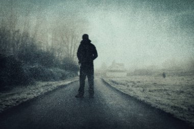 Kırsal kesimde bir yolda duran gizemli bir figür. Atmosferik kış gününde. Bir grunge, desenli düzenleme ile.