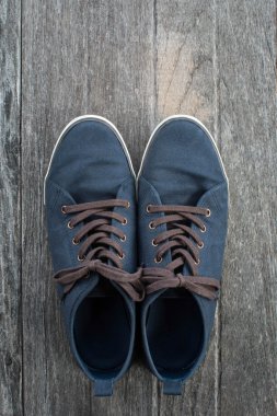 Eski ahşap zemin üzerine mavi spor ayakkabı