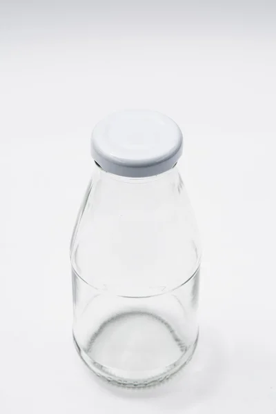 Botella de vidrio incoloro vacía sobre fondo blanco —  Fotos de Stock
