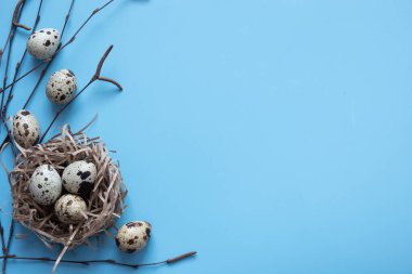 Mavi Paskalya yumurtaları ve kır masa odununda bir buket çiçek.