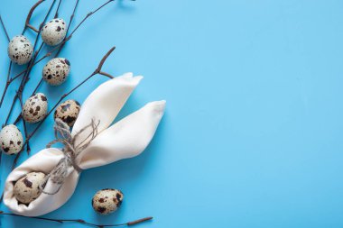 Mavi Paskalya yumurtaları ve kır masa odununda bir buket çiçek.