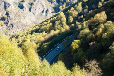 Yaz manzarası. Gün batımında tarladan geçen dağ yolu gökyüzüne doğru yükseliyor.