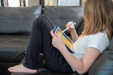 Kız dijital ressam tablet ya da dizüstü bilgisayarına stil çizer. O bir öğrenci ve resim eğitimi alıyor..