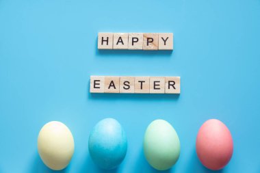 Mavi üzerine pastel renklerle boyanmış Paskalya yumurtaları. Paskalya konsepti