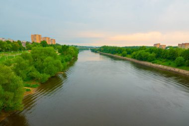 Sakin bir nehir boyunca uzanan uzun bir yaya ve su borusu köprüsünün güzel panoramik manzarası