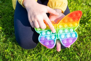 Renkli arka planda çocuklar ve yetişkinler için parlak gökkuşağı oyuncağı antistresi.